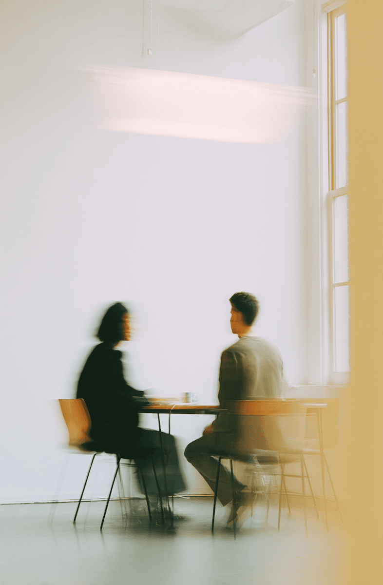 Two people meeting at a table in a bright minimalist office